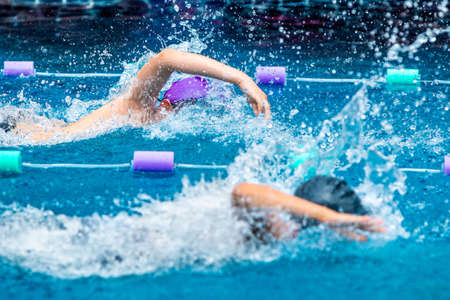 Young boy swimmers raceing furiously in freestyle stroke at a local poolの写真素材