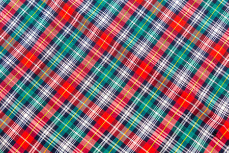 Close up of Christmas table cloth, showing red, green, and yellow stripe pattern