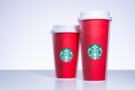 CHIANG MAI, THAILAND - 31 December 2018 - Starbucks take home holiday cups in various designs line up on white table against white background in Chiang Mai, Thailand on December 31, 2018のeditorial素材