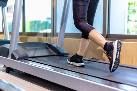 Female legs walking on treadmill at a gym, good for healthy lifestyle concept