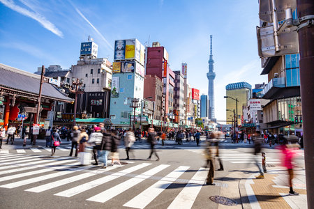 Asakusa, Japan - 24 February 2019 - Road traffic and pedestrians walk across streets in front of Asakusa temple in Japan on February 24, 2019