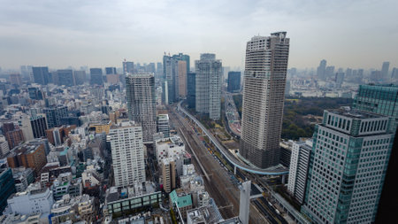 Arial view of busy Tokyo city in Japan showing dense highrise buildings, train tracks, and highways with background skyのeditorial素材