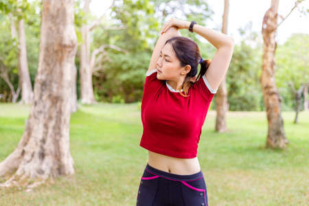 Side view of happy young athlete woman stretching her upper arm bicep before and after her morning...