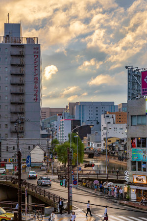 Fukuoka, Japan - 10 July 2019 - Pedestrians walk along busy streets of Fukuoka, Japan on a rainy evening of July 10, 2019のeditorial素材