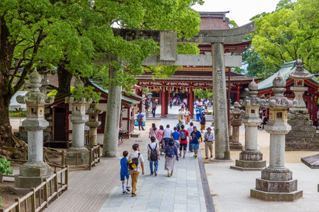 Dazaifu, Japan - 10 July 2019 - Tourists and local japanese people walk in and out through the entrance leading to the famous Tenmangu Shrine in Dazaifu, Japan on July 10, 2019のeditorial素材