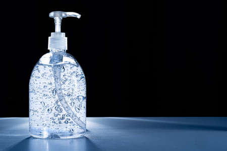 Anti-septic hand gel on white table with back lighting and black background, health conceptの写真素材