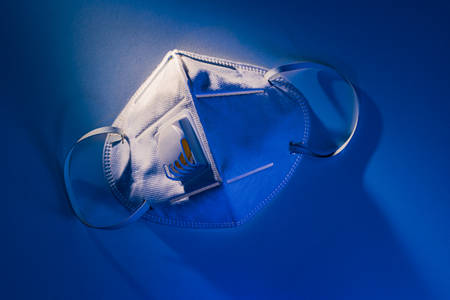 N95 mask on white table with dramatic blue lighting effect, health conceptの写真素材