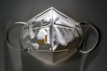 N95 mask on white table with dramatic contrasty lighting, health conceptの写真素材
