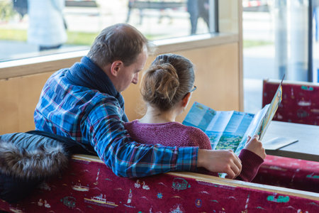 Prien am Chiemsee, Germany - 15 December 2019 - Western couple look at the map while wait for their boat at Chiemsee-shipping Ludwig FeÃler KG in Prien am Chemsee, Germany on December 2019のeditorial素材