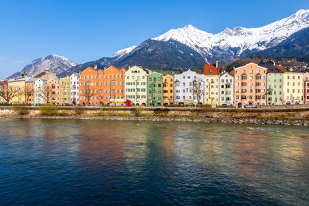 Innsbruck, Austria - 11 April 2015 - Panorama view of colorful buildings and mountains across from the flowing river of Innsbruck, Austriaのeditorial素材