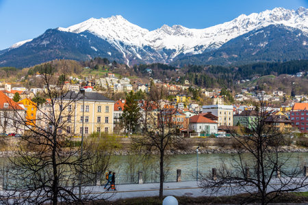 Innsbruck, Austria - 11 April 2015 - Panorama view of colorful buildings and mountains across from the flowing river of Innsbruck, Austriaのeditorial素材