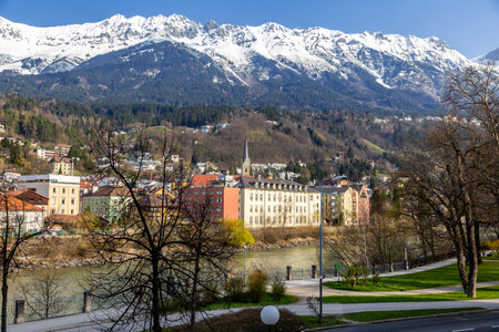 Innsbruck, Austria - 11 April 2015 - Panorama view of colorful buildings and mountains across from the flowing river of Innsbruck, Austriaのeditorial素材