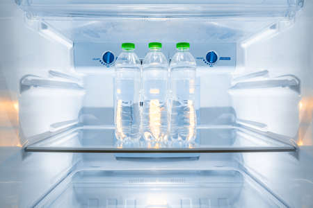 Cold bottles of clean drinking water in a white refrigeratorの写真素材