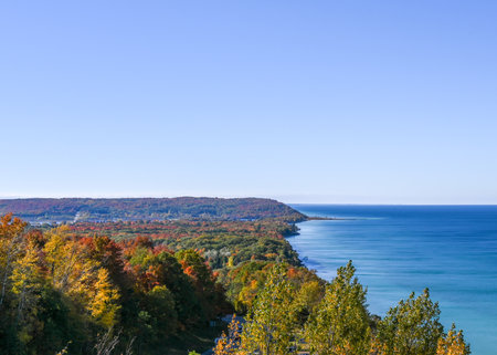 Horizontal image of lake michigan framed by autumn trees under a clear blue skyの写真素材