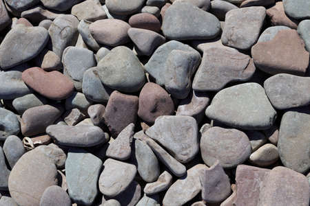 A selection of grey and pink coloured pebbles on a beachの写真素材