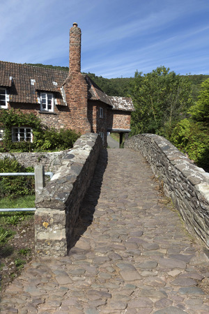 Packhorse bridge over the stream in the pretty village of Allerford in the county of Somerset in the UKの写真素材