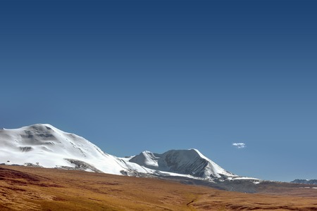 Snow mountain on the blue sky backgroud and brown landの写真素材