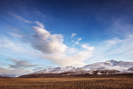 Mountais with trees on the blue cloudy skyの写真素材