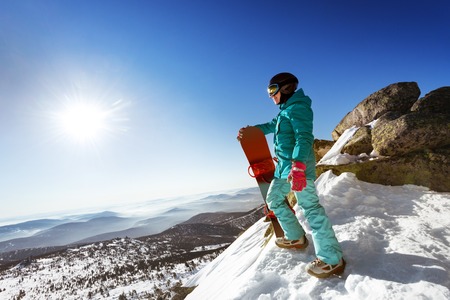 Snowboarder stands on valley and mountains backdrop. Space for text. Sheregesh resort, Siberia, Russiaの写真素材