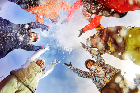 Bright color snowboarders throw snow on blue sky backdrop. Sheregesh, Siberia, Russiaの写真素材