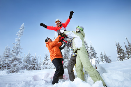 Bright color snowboarders posing like a fly on blue sky backdrop. Sheregesh, Siberia, Russiaの写真素材