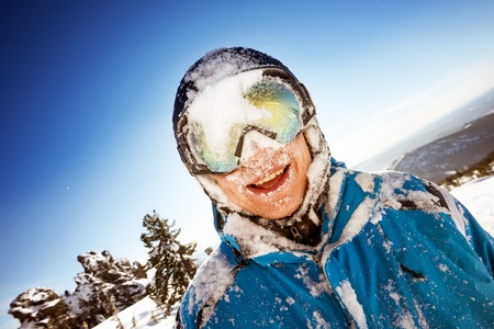 Bright color snowboarder posing on blue sky backdrop. Sheregesh, Siberia, Russiaの写真素材