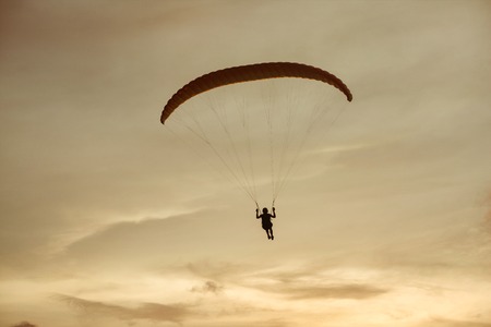 Paraglider flies on background of the sky sunsetの写真素材