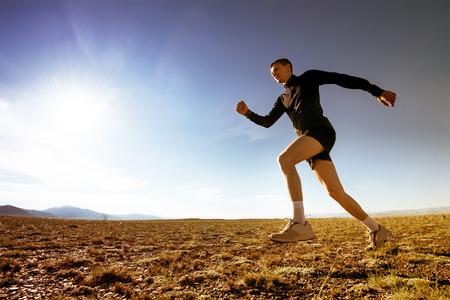Sportsman running on the blue sky backgroundの写真素材