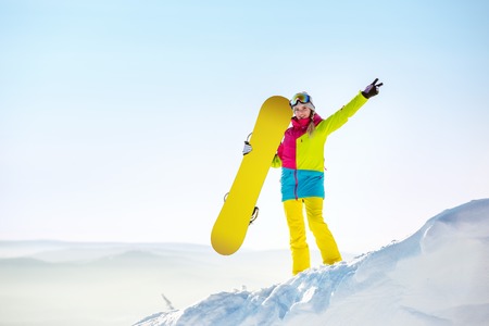 Happy girl snowboarder copyspace top mountainの写真素材