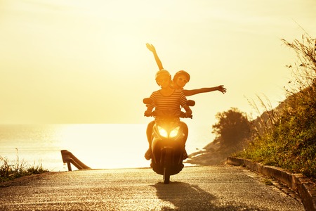 Happy couple travel motorcycle sea roadの写真素材
