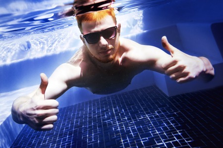 Man underwater swimming pool funの写真素材
