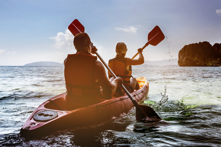 Man and woman kayaking in seaの写真素材