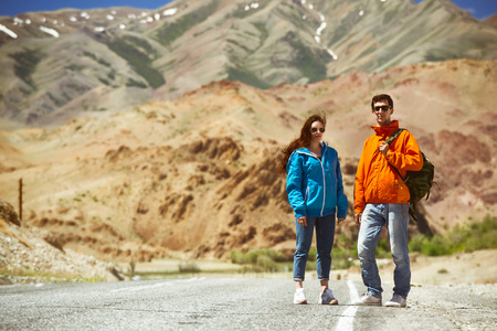 Couple backpackers on mountain roadの写真素材