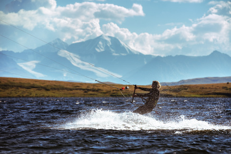 Woman kite surfing in mountain lakeの写真素材