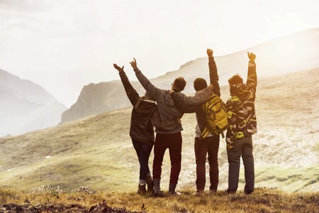 Four friends having fun mountain sunsetの写真素材