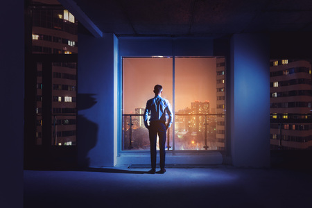 Office worker employee near big window night