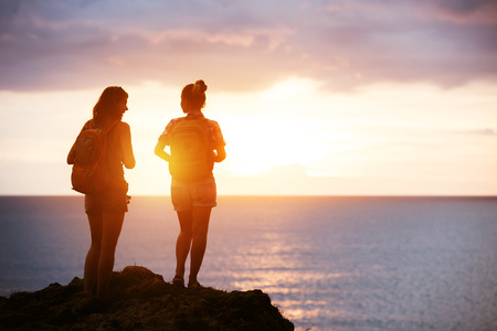 Two girls travel sea sunset conceptの写真素材