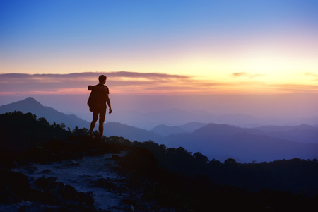 Mans silhouette on sunset mountains backdropの写真素材