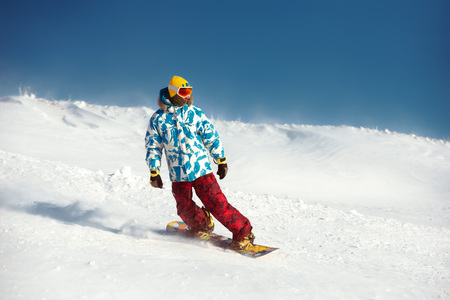 Snowboarder downhill at ski slopeの写真素材