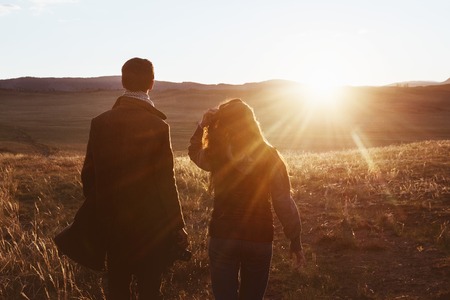 Couple travellers against sunset mountain