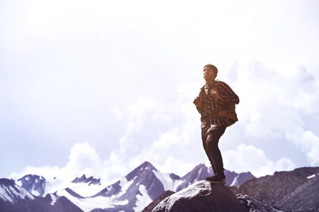 Travel adventure or trekkinng concept with single man against mountainsの写真素材