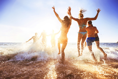 Happy friends at sunset sea beachの写真素材