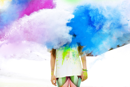 Woman stands in colorful cloudの写真素材