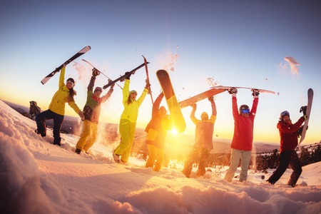 Happy friends at ski resort having fun sunsetの写真素材