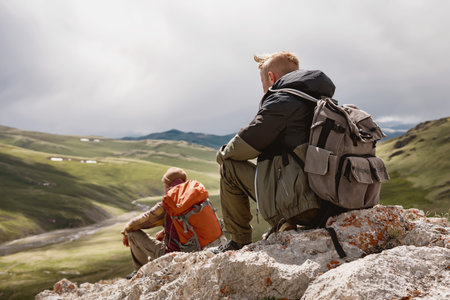 Two hikers sit and relax in mountainsの写真素材