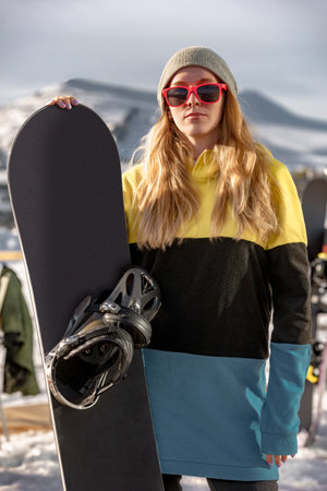 Portrait of girl snowboarder standing with snowboard at ski resort. Sheregesh Russia.の写真素材