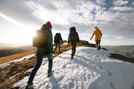 Group of young tourists hikers walks on mountain top with backpacks. Active life conceptの写真素材
