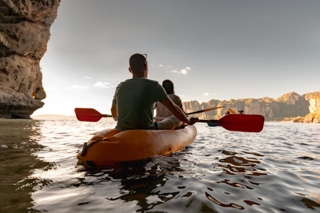 Couple kayakers are walking on kayak at tropical sea bay