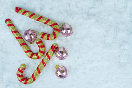 Gold and red candy canes with glitter Christmas baubles on the snow. Copy spaceの写真素材