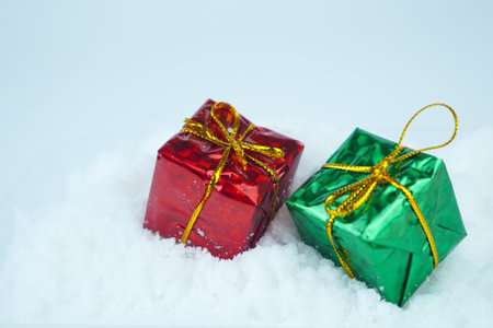 Red green present with metallic string on the snow. Copy spaceの写真素材
